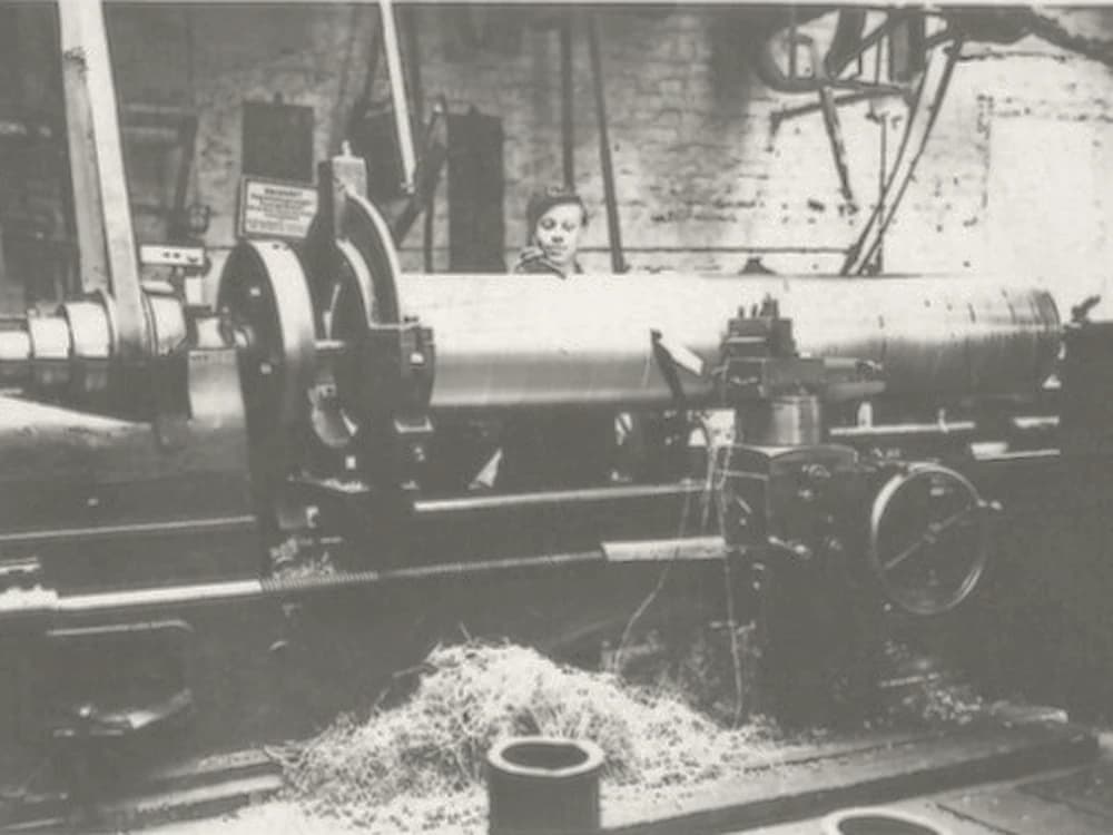 Historic photograph of lathe work on a large shaft in an early FUKA workshop
