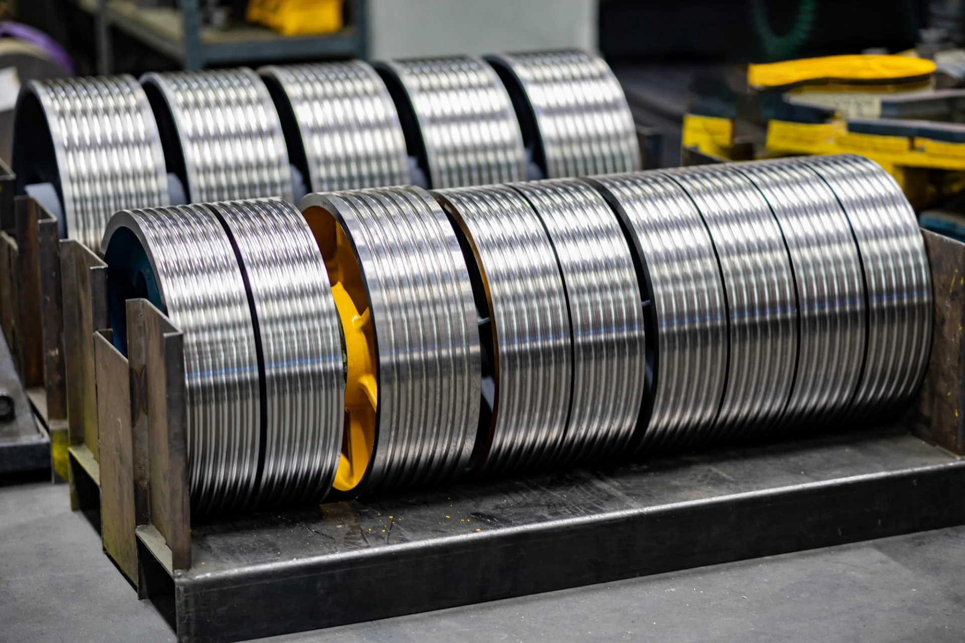 Rows of machined elevator traction sheaves with finished rope grooves at FUKA
